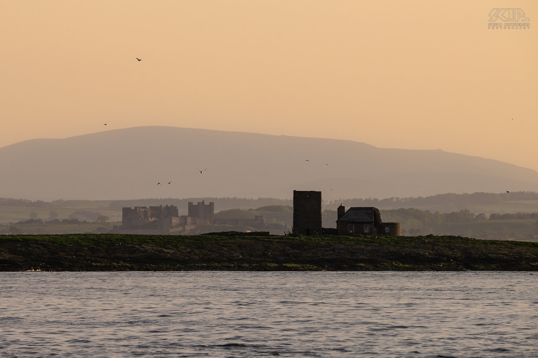 Farne Islands - Brownsman lighthouse De oude vierkante toren van de eerste vuurtoren op Brownsman Island is niet meer in gebruik. Op het vasteland kun je het indrukwekkende Bamburgh Castle zien. Stefan Cruysberghs